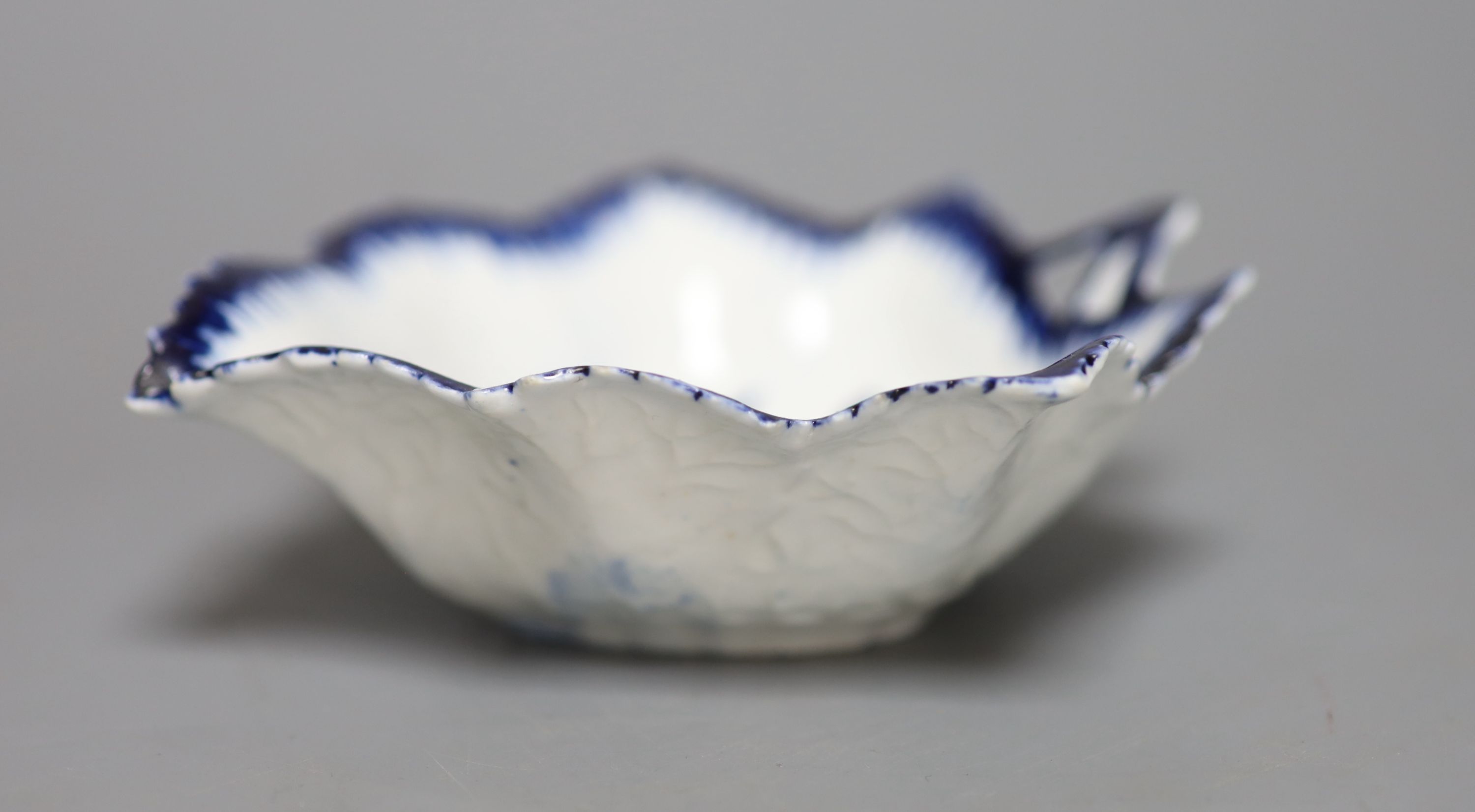 An 18th century Derby leaf shaped pickle dish decorated with flowers, in blue under a feather edge border, length 12cm